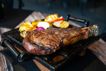 Grilled meat and vegetables. T-bone steak in a restaurant.