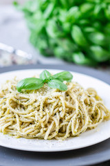 Cooked spaghetti pasta on a plate with basil pesto and Parmesan cheese, Italy food, healthy concept, vegetarian
