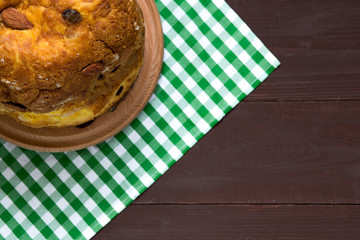 Italian traditional Christmas panettone with dried fruits and orange zest on wooden background