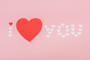 background with 'i love you' lettering made of paper hearts isolated on pink, st valentines day concept