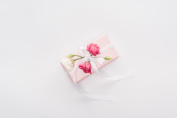 top view of gift box with ribbon and flowers isolated on white