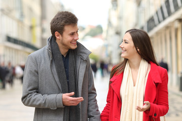 Couple walking and talking in winter in the street