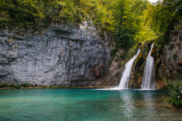 Fototapeta na wymiar The main natural landmark of Croatia is the Plitvice Lakes with cascades of waterfalls. Emerald clear cold water on the background of rocks, plants and trees.