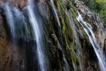 The main natural landmark of Croatia is the Plitvice Lakes with cascades of waterfalls. Emerald clear cold water on the background of rocks, plants and trees.