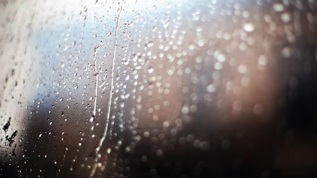 Color close up footage of rain drops on a window.