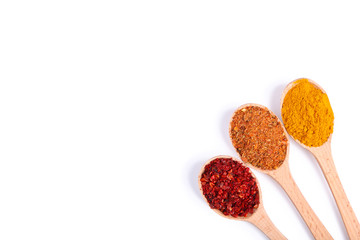 Spices mix on wooden spoons on a white wooden background. Top view