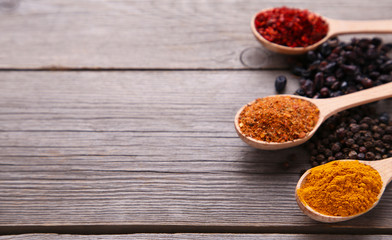 Spices mix on wooden spoons on a grey wooden background. Top view