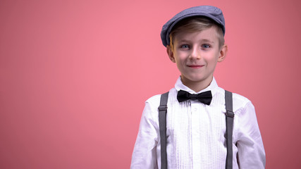 Little gentleman in vintage clothes surprisingly looking into camera, happiness