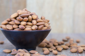 Almond nut on wood background.