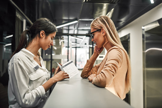 Young Woman At Reception Or Front Office Asking Service Catalog Of Hotel