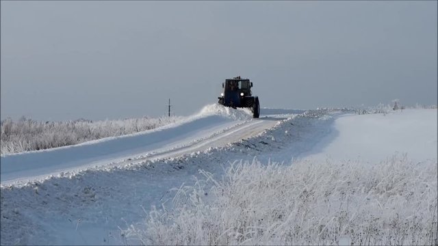 Tver region. Sonkovsky district. Russia. 
 28 January 2019. Clearing snow from the road. Tractor grader clears snow from the road. 