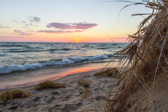 Michigan Sunset Beach. Gorgeous sunset over a sandy beach on the coast of Lake Michigan with dune grass in the foreground.