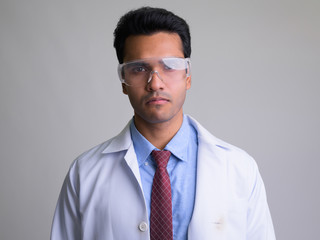Face of young Indian man doctor with protective glasses