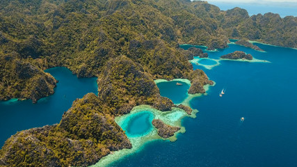 Fototapeta na wymiar Aerial view: Mountain Barracuda lake, on tropical island, Lagoon with blue, azure water. Lake in the mountains covered with tropical forest on the island Coron, Palawan, Philippines.