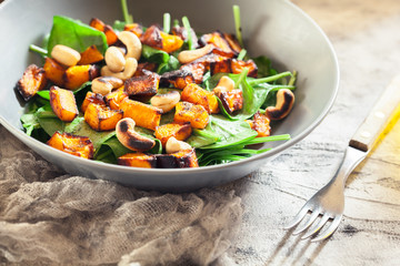 Roasted pumpkin salad with spinach and nuts