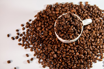 white cup with a pattern and coffee beans