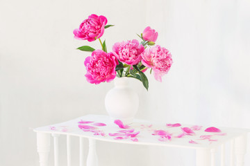 pink peonies in vase on vintage white wooden shelf