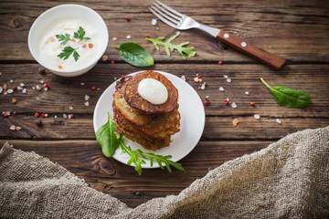 potato pancakes with sour cream on  wooden table