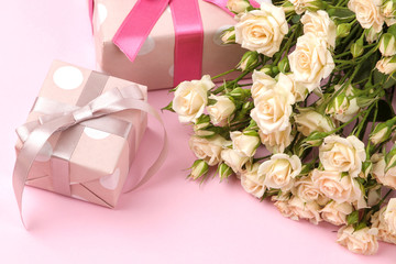 Beautiful mini roses with a pink gift box on a bright pink background. holidays. Valentine's Day. women's Day.