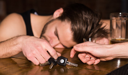 Warning of car accident. Alcoholic man with car keys sleeping at bar counter. Man after drinking strong alcohol and beer in pub. Alcohol addict with alcohol drink. Alcohol addiction and bad habit