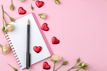 Beautiful mini roses with a cup of coffee and a notebook on a bright pink background. holidays. Valentine's Day. women's Day. view from above. space for text