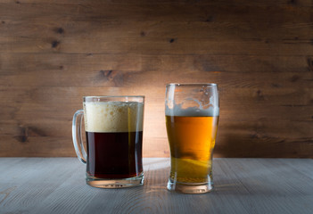 Two glasses of different colored beer on wooden background