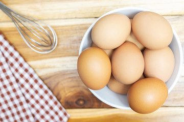 Preparation raw materials cooking for baking whisking chicken eggs in glass bowl on kitchen table wooden. Free space for text . Top view. soft focus.
