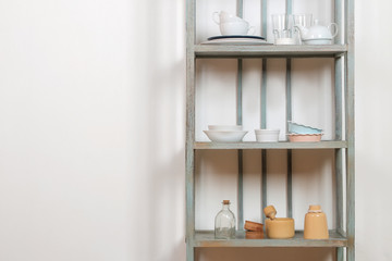 Fototapeta na wymiar Vintage shelf with kitchenware on a white wall background. antique shelf. interior