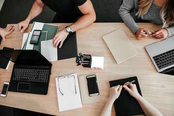 Co-working business people at one table a top view. Work for laptops on the table. Startup...