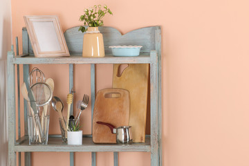Vintage shelf with kitchenware in the background of the peach wall. antique shelf. interior