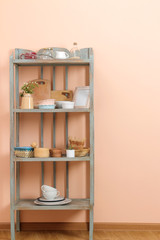 Fototapeta na wymiar Vintage shelf with kitchenware in the background of the peach wall. antique shelf. interior