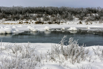 Winter landscape by a river in the sunset