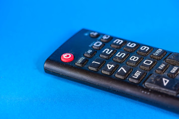 Obraz premium Part of old dirty tv remote console isolated on blue background