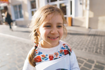 smiling girl holding book in street