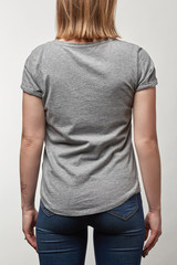 Obraz premium back view of young woman in grey t-shirt with copy space isolated on white