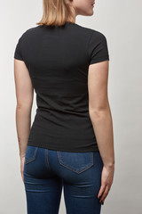 Obraz premium back view of young woman in black t-shirt with copy space isolated on white