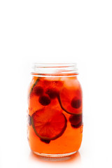 Red cocktail with cherry and lime in jar isolated on white background. Selective focus. Shallow depth of field.