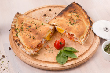 Calzone pizza on light wooden background