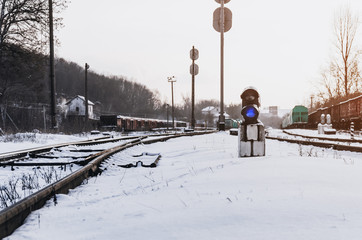 Vintage railway traffic light on an old snow covered railway station. Trains, rails, travel,...