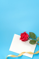 Fototapeta premium Beautiful greeting card with golden ribbon for Valentine's day, anniversary, mother's day and birthday on blue background, copyspace, topview, mockup, flatlay