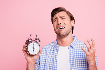 Close up photo of beautiful amazing brunet he him his handsome with metal alarm clock in hand arm...