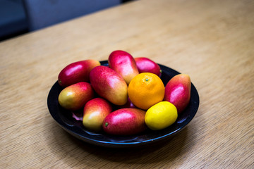 Apple mangos, oranges, and lemons in the bowl in the kitchen