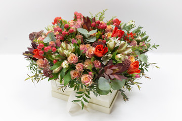 Flower arrangement (bouquet) of fresh flowers (red, pink, beard) in a cardboard box on a white background