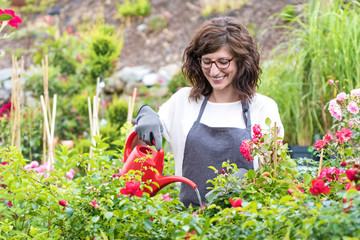Gärtnerin hat Spaß beim gießen der Rosenpflanzen