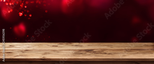 Dark background with red hearts and wooden table