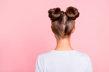 Rear back behind view of nice attractive groomed girl wearing two fashionable buns isolated over...