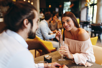 Young happy couple at a date in a coffee shop