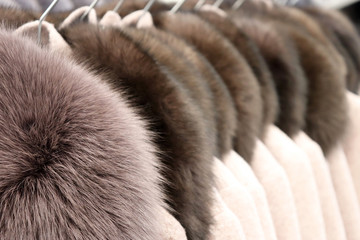 Luxury fur coats in a row on a hanger in the store. Female fashion, natural fur clothes from mink...