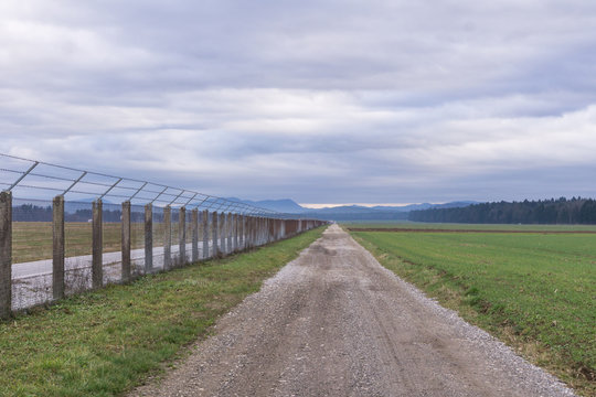 Long country road going straight on with fence on the right © 24K-Production