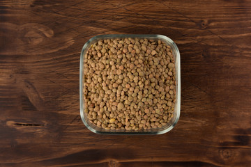 Yellow lentil in a bowl on wooden background